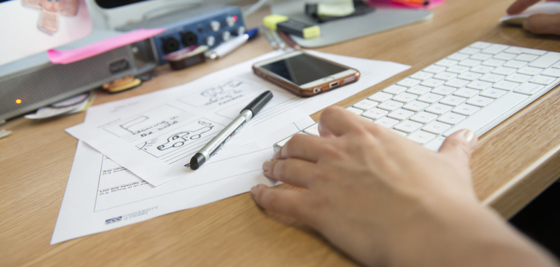 phone and notes by a computer keyboard